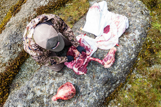 Hunter organizing elk meat bags head tag and packout gear during CWD testing preparation