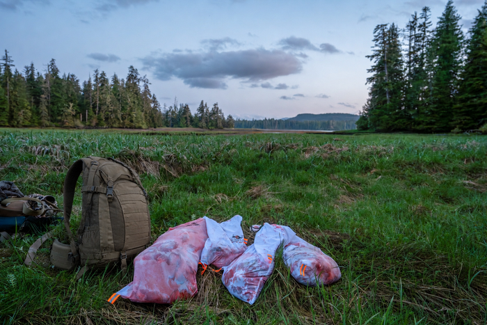 Elk game bags staged on a Western mountain packout with breathable white bags and organized meat loads