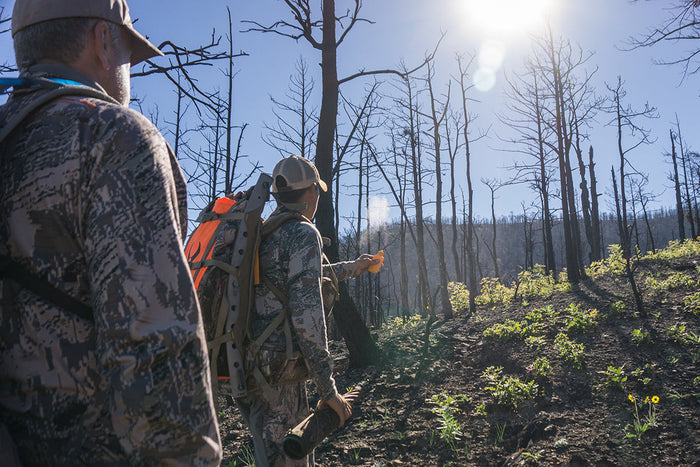Hunter glassing from distance with a map and notes, applying pressure management strategy during spring scouting