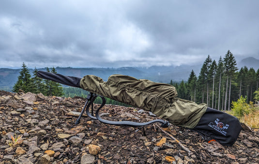 Waterproof hunting rifle cover protecting a scoped rifle during wet Western mountain travel