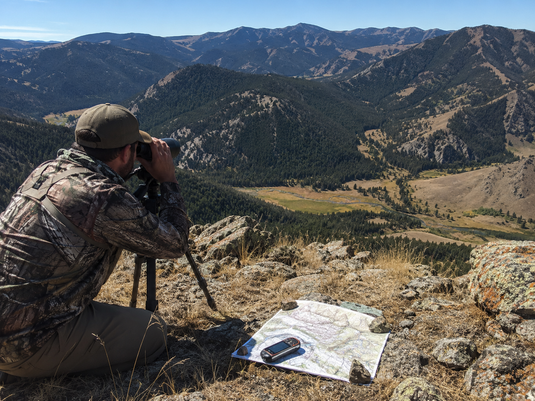 Western hunter glassing elk country from a distance to avoid disturbing a scouting area before season
